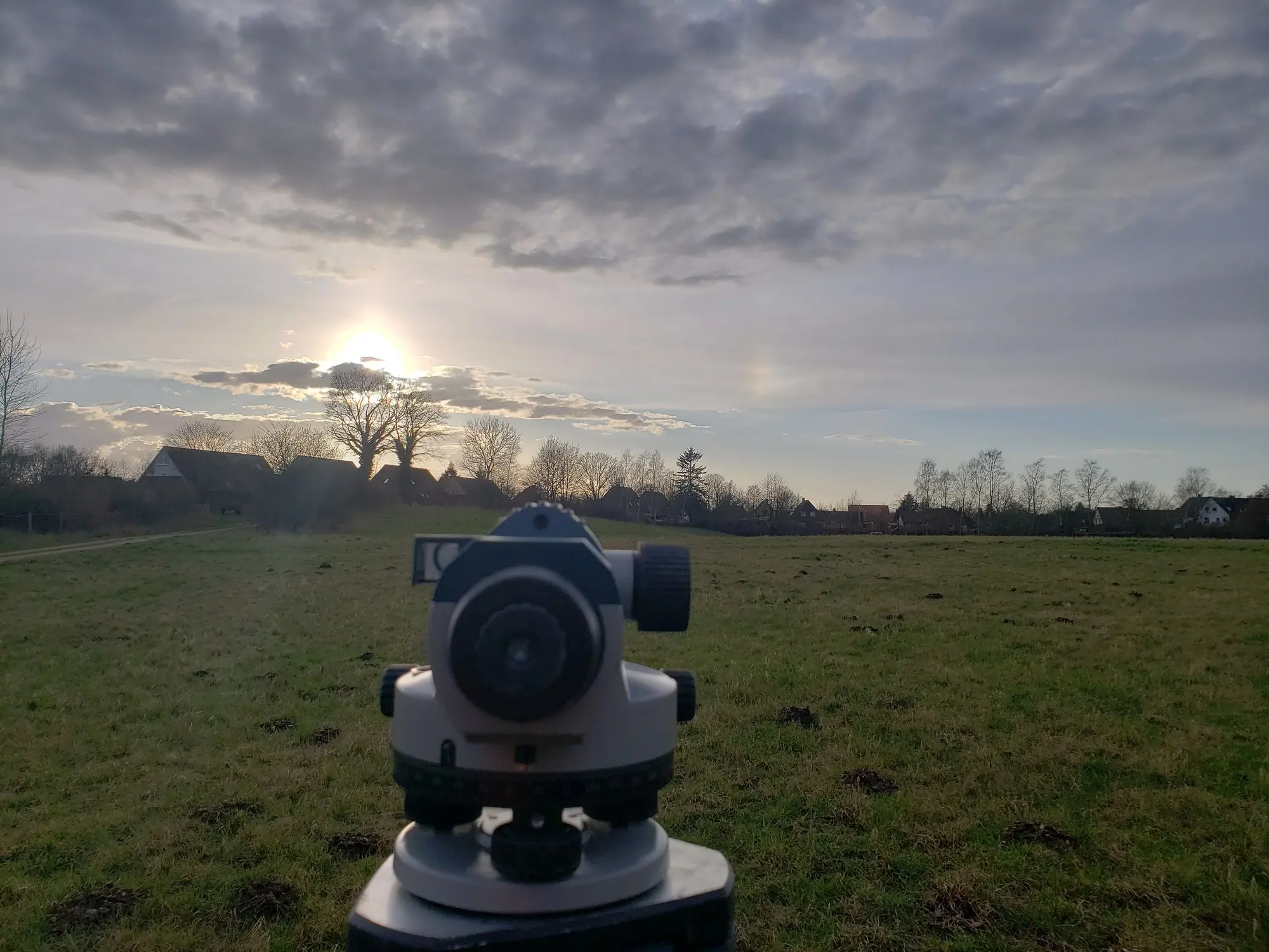 Nivelliergerät auf einer Wiese im Abendlicht