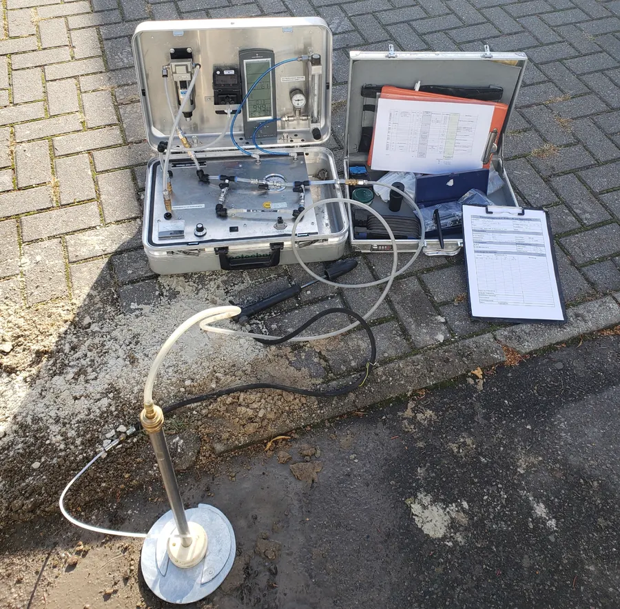 Messkoffer mit Durchflusszelle und Feldmessprotokoll an einer Gas-Messstelle im Gehweg
