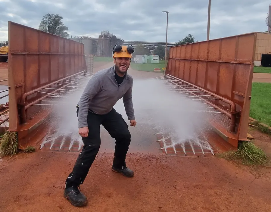 Mitarbeiter von TERRA V beim Reinigen eines Containers, das Wasser spritzt
